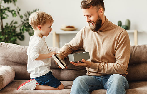 guy opening present with son